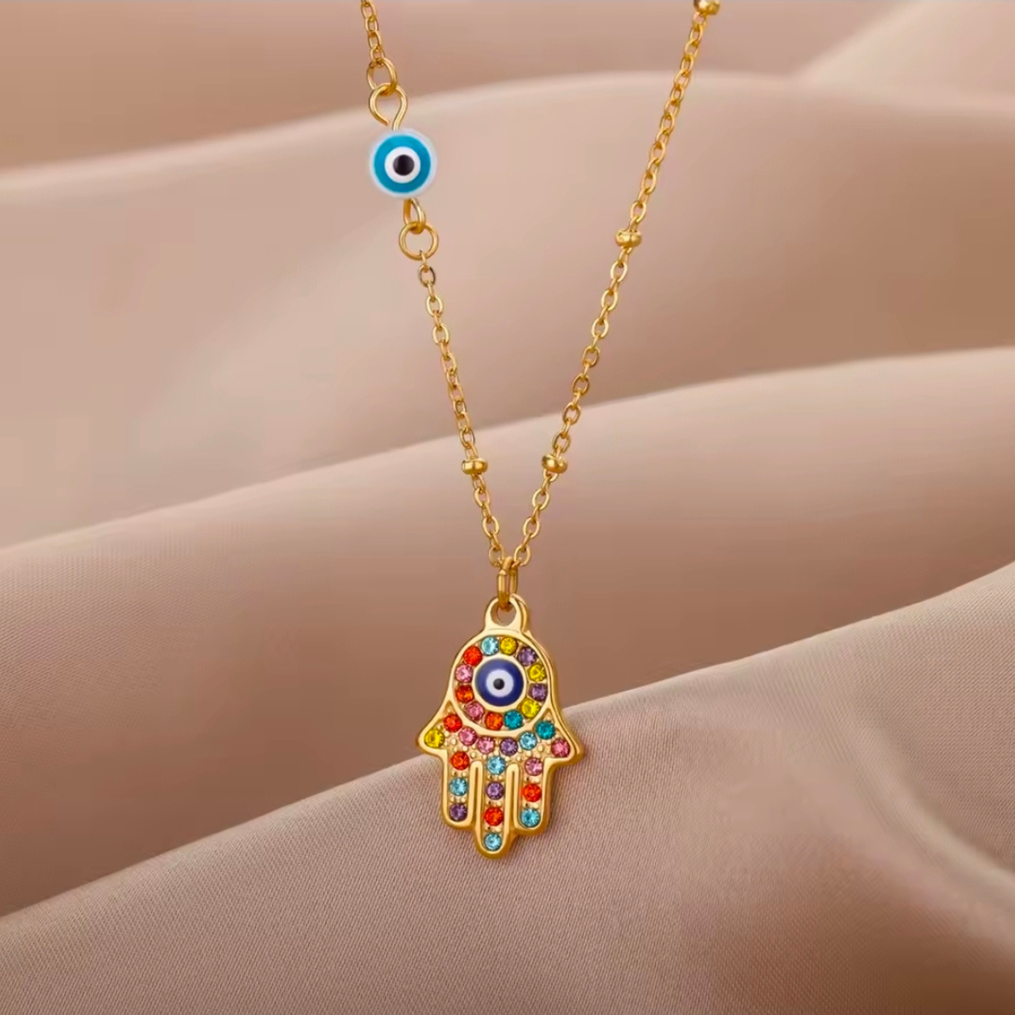 Necklace with a colorful Hamsa hand pendant on a beige background