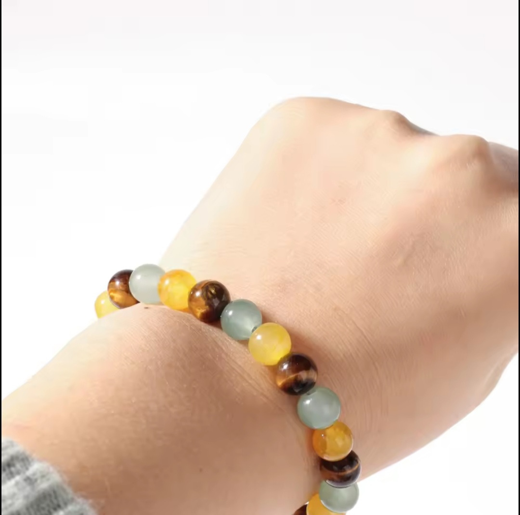 Multicolored beaded bracelet on a wrist against a white background