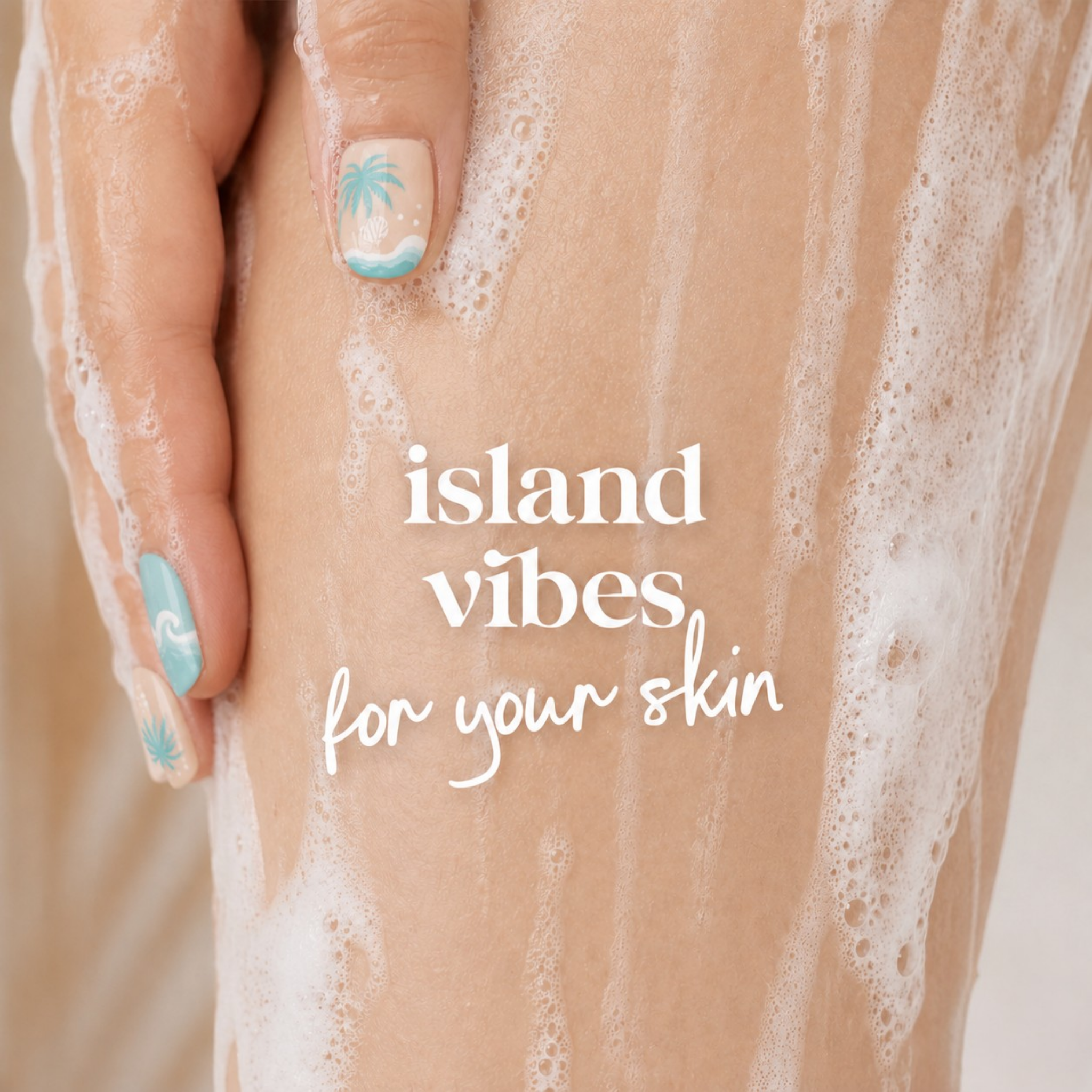 A close-up of a hand with light blue and white nail art resting on a leg covered in white soap foam, with the text 'island vibes for your skin' overlaid in white script.