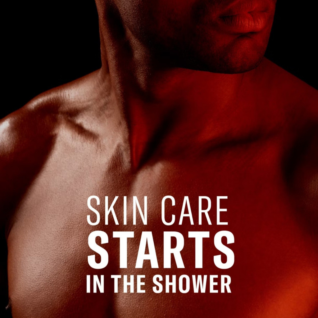 A close-up of a shirtless male torso with dramatic red lighting against a black background, with the text 'SKIN CARE STARTS IN THE SHOWER' overlaid in large white letters.