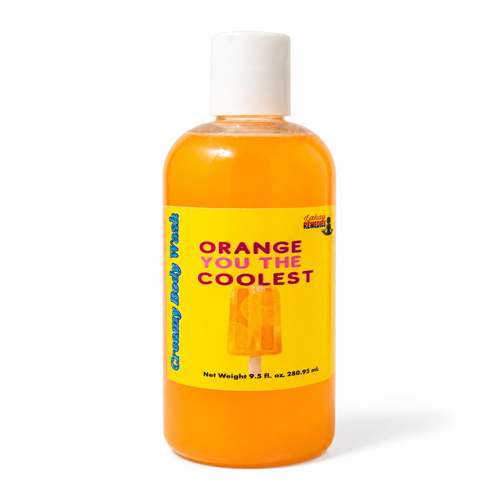A bottle of orange body wash with a white cap and a bright yellow label that reads 'ORANGE YOU THE COOLEST' and 'Creamy Body Wash.' The bottle is centered on a white background.