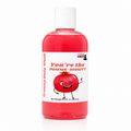 A bottle of Lakay Remedies 'You're the Pomme-Diggity' creamy body wash, featuring a red liquid inside a clear bottle with a white cap and a white label with a cartoon pomegranate.