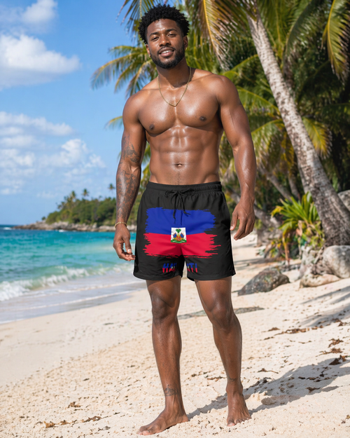 Man wearing black swim shorts with a Haiti design on a beach