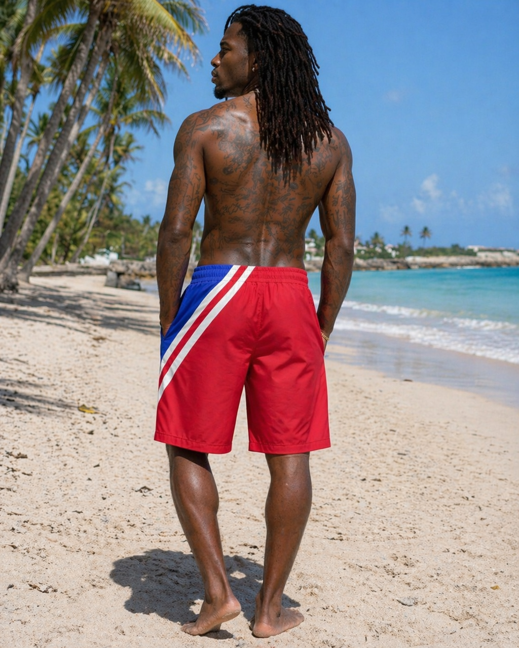 Man wearing red swim shorts on a beach.