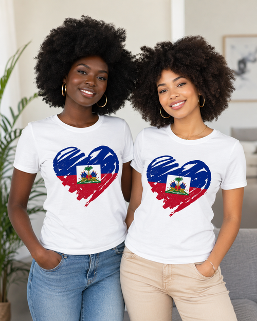 Two women wearing white t-shirts with a heart design featuring the Haitian flag, standing indoors.