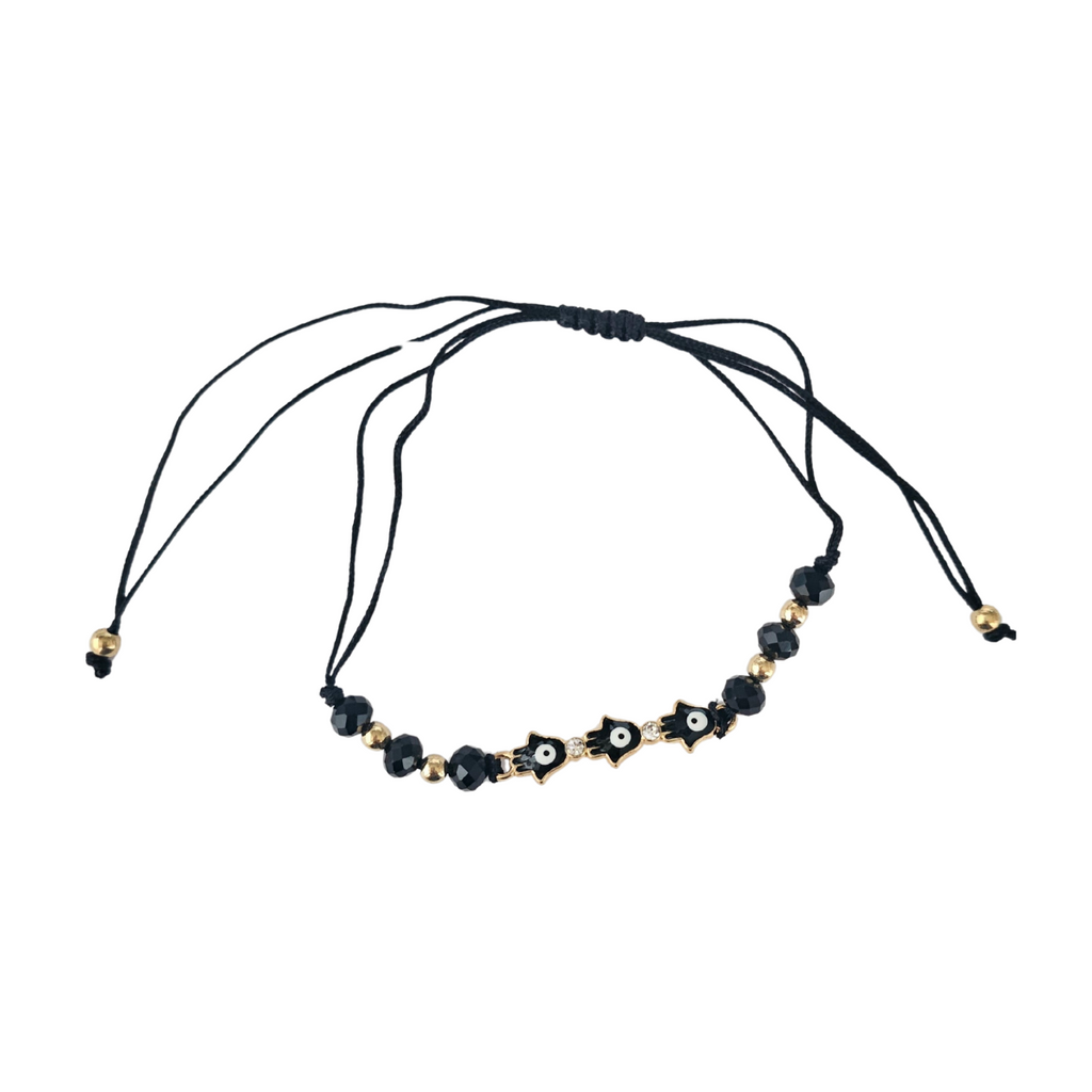 Necklace with black beads ane evil eye elements on a white background