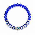 Blue beaded bracelet with evil eye charms on a white background