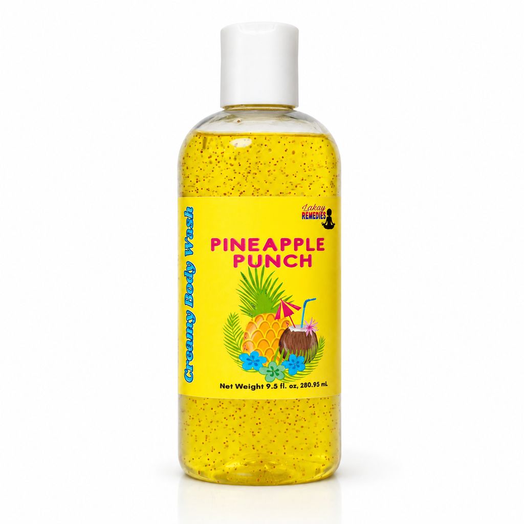 A clear plastic bottle of body wash with a white cap, filled with yellow liquid speckled with jojoba beads. The bottle features a bright yellow label with the text 'PINEAPPLE PUNCH' in pink, along with illustrations of pineapples, coconuts, and tropical flowers.