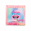 A square bar of pink soap wrapped in clear plastic with a colorful front label reading 'HER BEAUTY FACTORY Soap Yoni Taste like candy' and showing lips with a candy graphic, on a white background.