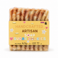 A packaged bar of handmade artisan soap shaped like sugar cookies, wrapped in clear plastic with a yellow label reading 'HANDCRAFTED ARTISAN SOAP SUGAR COOKIES' and 'Lakay Remedies' at the top right, on a white background.