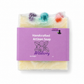 A packaged handmade artisan soap bar labeled 'Wildberry' by Lakay Remedies, wrapped in clear plastic with a purple paper label and colorful berry-like inclusions visible at the top.