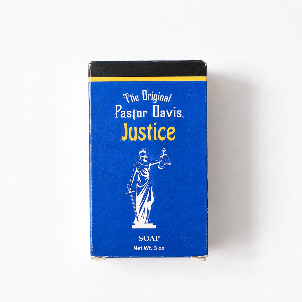 A 3 oz box of Justice Soap by The Original Pastor Davis, featuring a vibrant blue front with a white statue of Justice and yellow lettering, set against a plain white background.