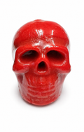 Red skull-shaped candle on a white background
