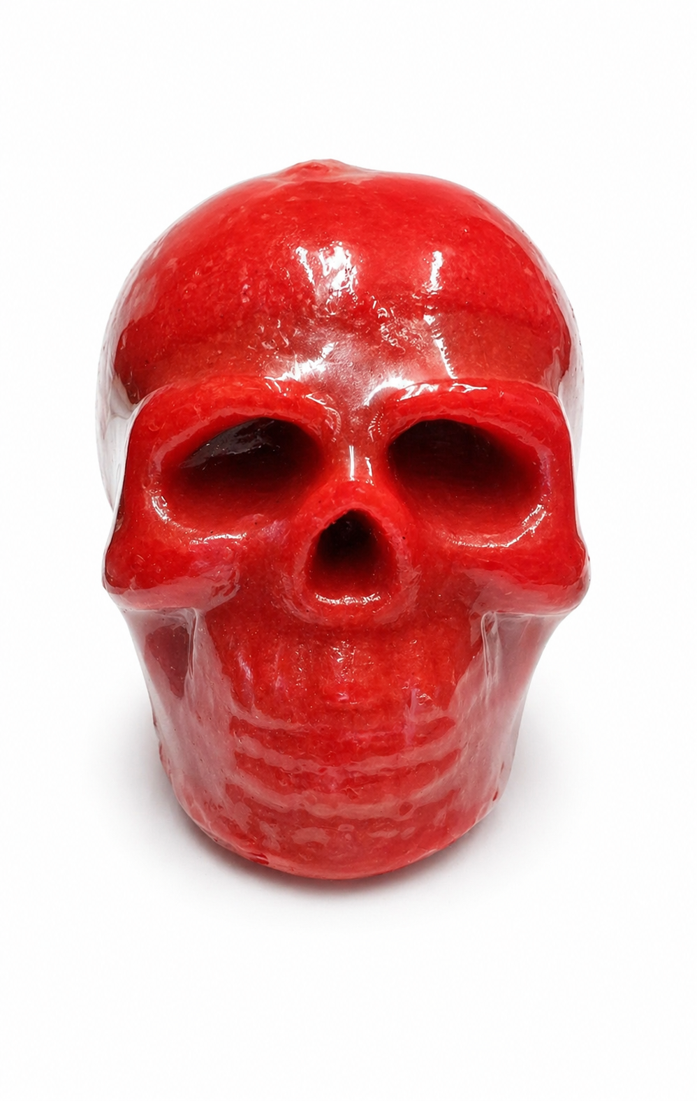 Red skull-shaped candle on a white background
