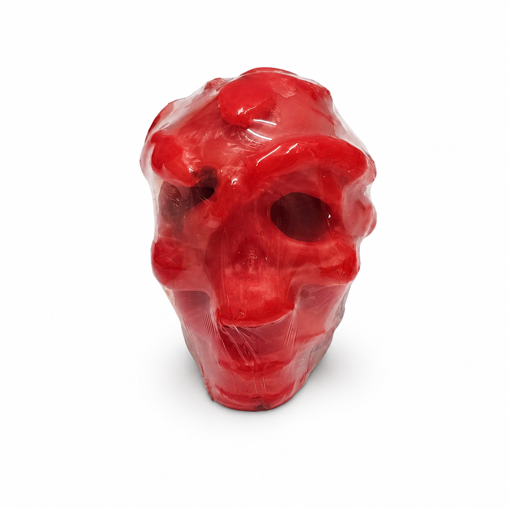 Red skull-shaped candle on a white background