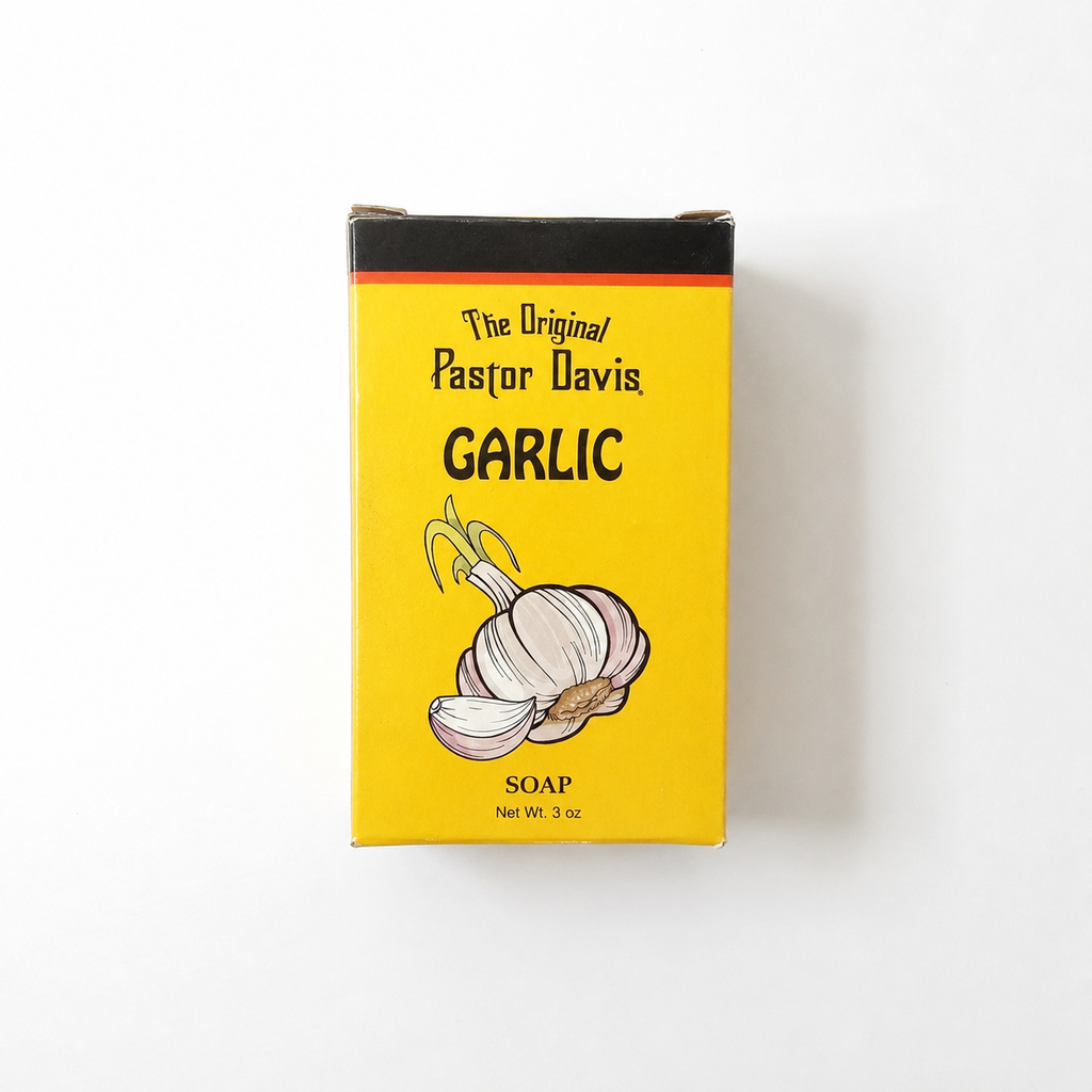 A 3 oz box of The Original Pastor Davis Garlic Soap, featuring a bright yellow label with a black top border, black text, and an illustration of a garlic bulb on a white background.