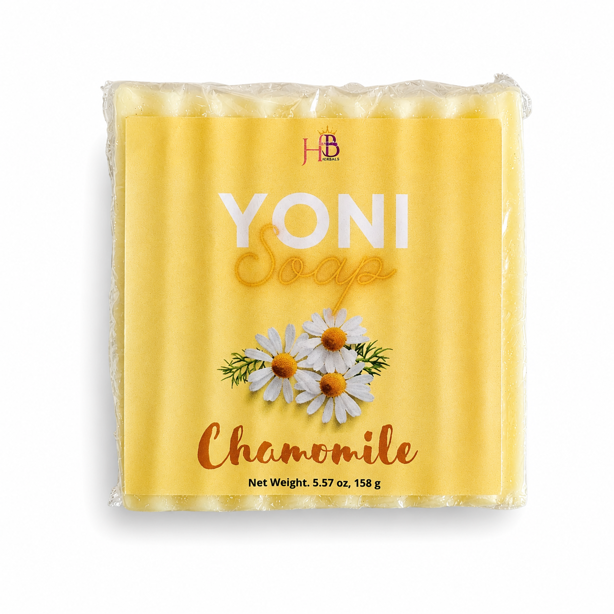 A packaged bar of yellow chamomile soap in a clear plastic wrapper with a printed label. The label features the brand initials Her Beauty Factory at the top, the words 'YONI Soap' in large white and gold lettering, 'Chamomile' in orange script, and an illustration of three white chamomile flowers with yellow centers.