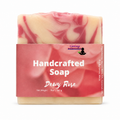 A 5 oz bar of handcrafted soap labeled 'Dewy Rose' by Inkay Remedies, featuring a pink and cream marbled pattern with a pink paper label.