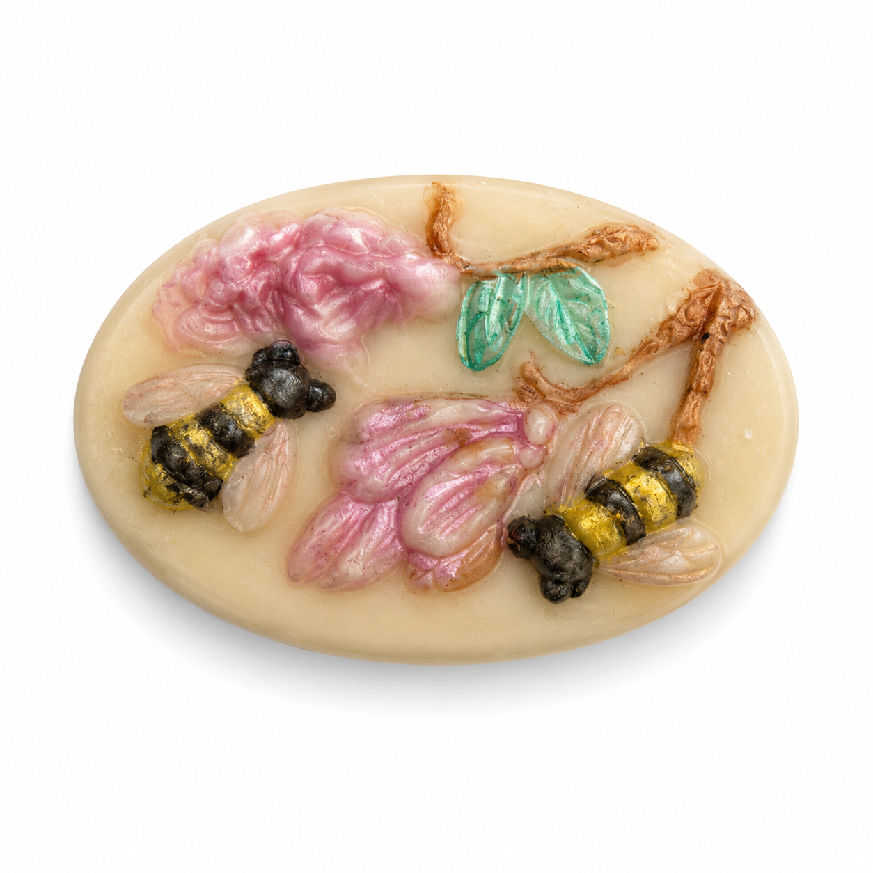 An oval cream-colored resin cabochon featuring raised pink flowers, green leaves, and two yellow-and-black bumblebees, shown on a plain white background.