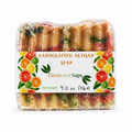 A packaged bar of handmade artisan soap labeled 'Citrus and Sage,' wrapped in clear plastic with a white paper band decorated with citrus slices and sage leaves. The soap itself appears multicolored with yellow, red, green, and orange tones visible through the transparent wrapping.