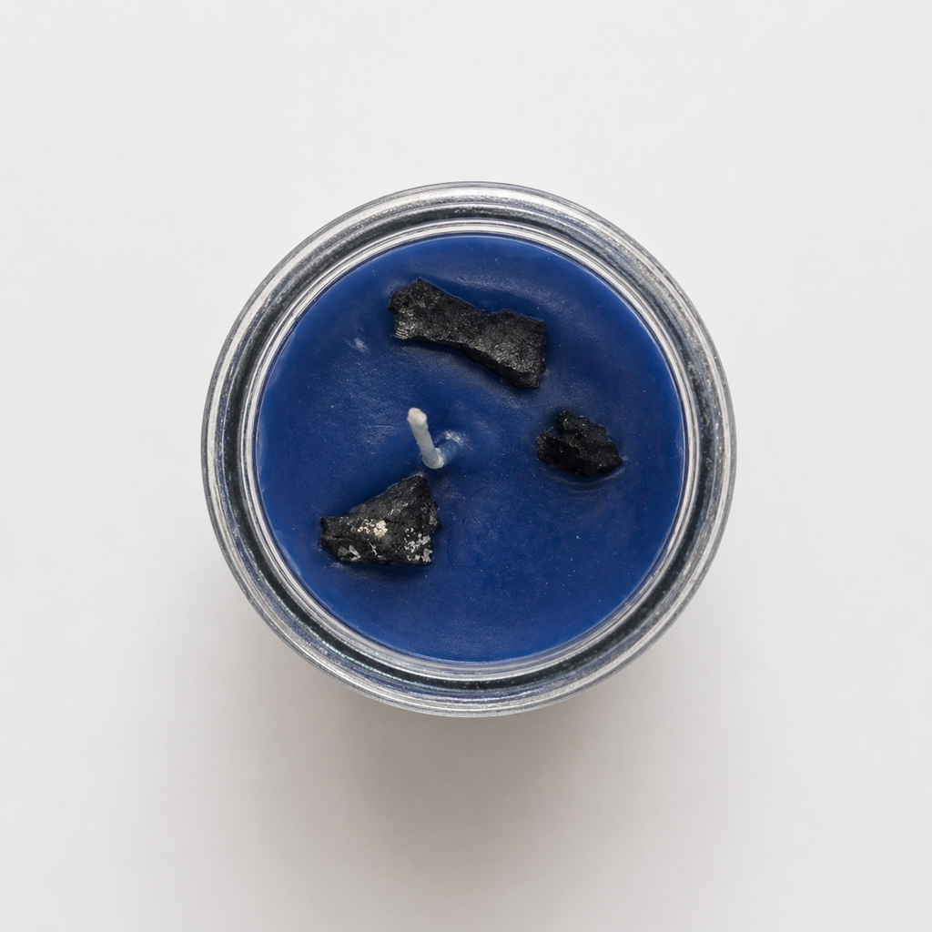 Blue candle with white wicks in a glass jar on a white background