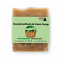 A single bar of handmade soap wrapped in clear plastic with a light green paper label. The label reads 'Handcrafted Artisan Soap' and 'PEPPERMINT CHOCOLATE,' with a cupcake illustration.