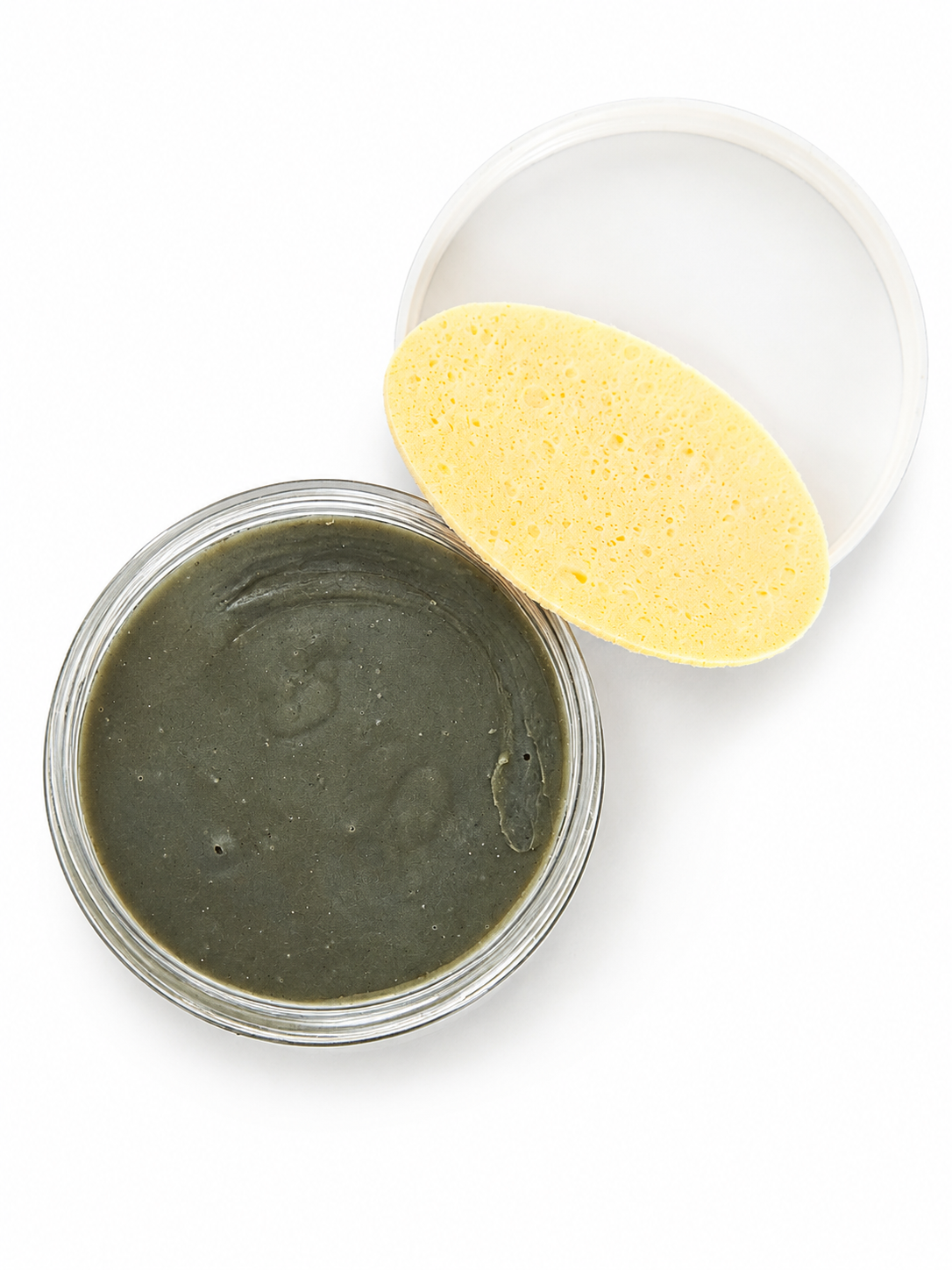 A round  jar filled Clear Even Tone Body Cleansing Bar, shown with its white lid and a yellow oval sponge on a white background.