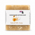 A rectangular bar of handmade artisan soap in a light tan, oatmeal-colored shade, wrapped in a white paper label that reads 'HANDCRAFTED ARTISAN SOAP' and 'Oatmeal Milk & Honey'. The brand 'Lakay Remedies' is visible on the label.