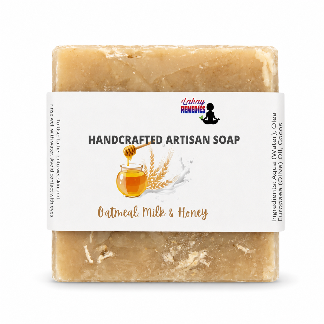 A rectangular bar of handmade artisan soap in a light tan, oatmeal-colored shade, wrapped in a white paper label that reads 'HANDCRAFTED ARTISAN SOAP' and 'Oatmeal Milk & Honey'. The brand 'Lakay Remedies' is visible on the label.