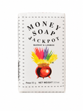A single rectangular bar of Money Soap Jackpot by Murray & Lanman, featuring a white wrapper with black text and a colorful illustration of a pot of gold with rainbow feathers, photographed on a white background.