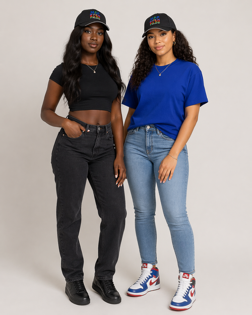 Two women wearing black and blue tops with jeans and sneakers on a plain background