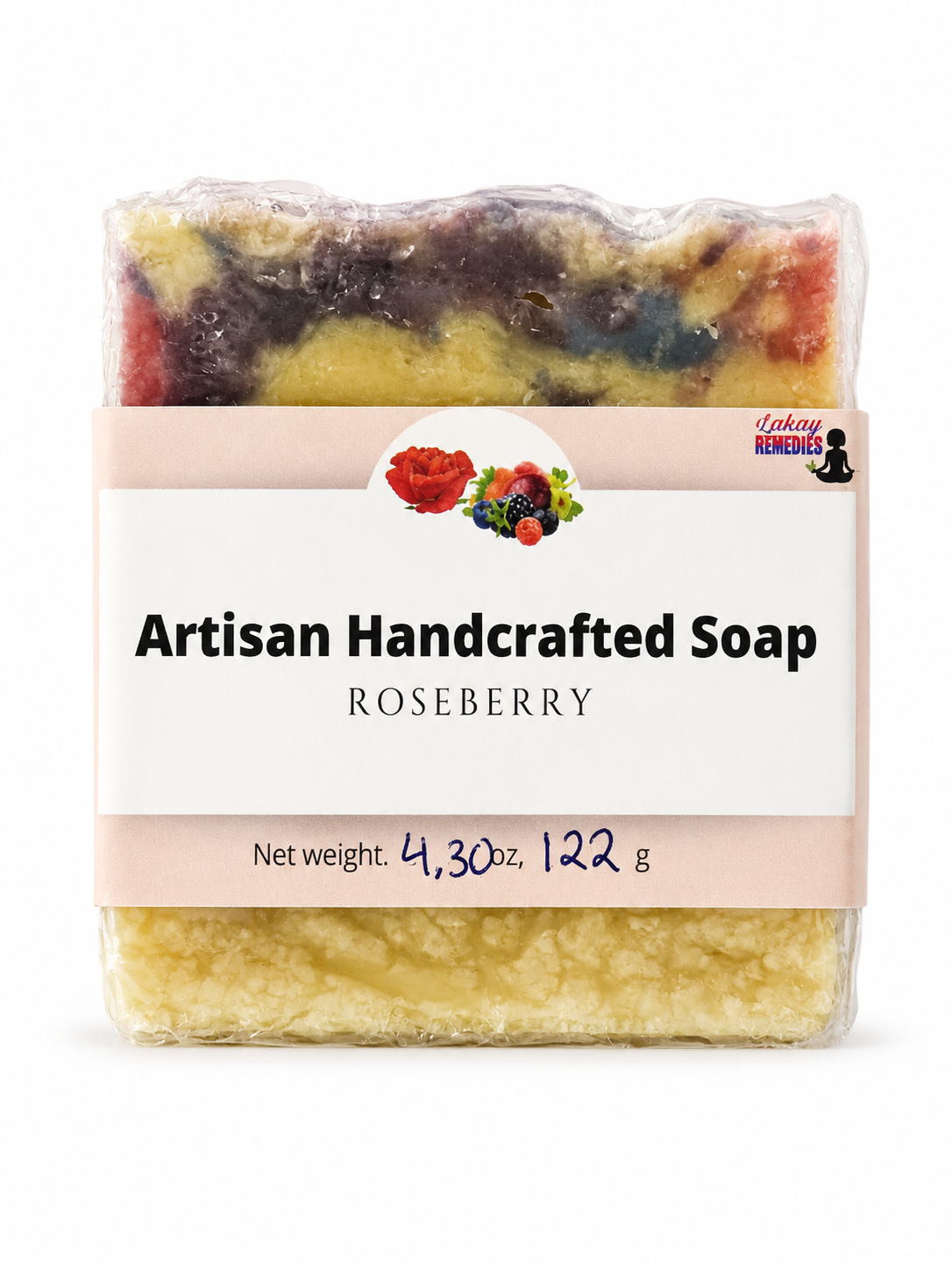 A packaged handmade soap bar labeled 'Artisan Handcrafted Soap ROSEBERRY' with a white paper band around the clear plastic-wrapped soap. The soap itself shows marbled yellow, red, and dark purple tones, and the label includes a small logo for 'Lakay Remedies.
