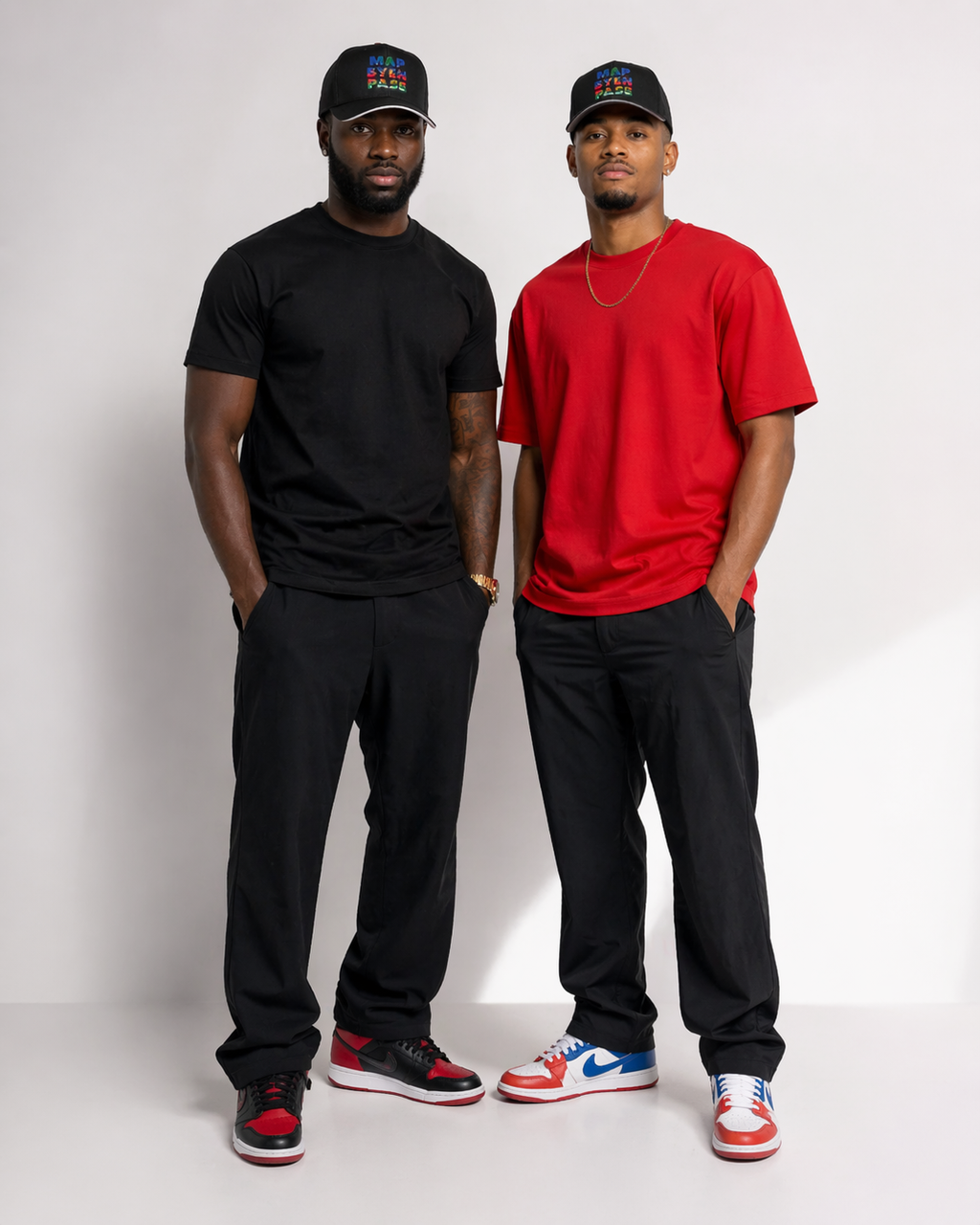 Two men standing side by side, one in a black outfit and the other in a red outfit, on a white background.