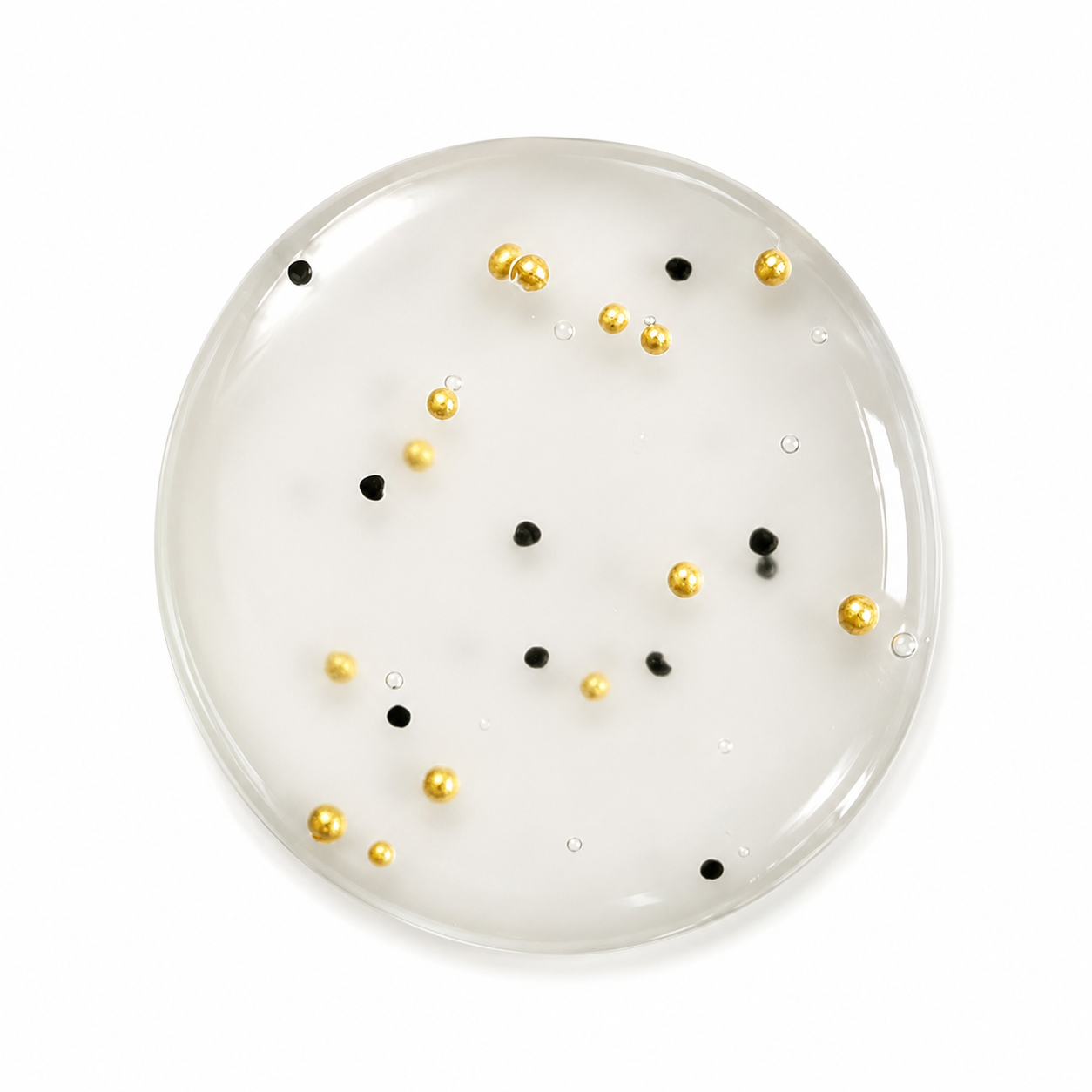 A round clear body wash featuring gold jojoba bead and black jojoba beads on a white background.